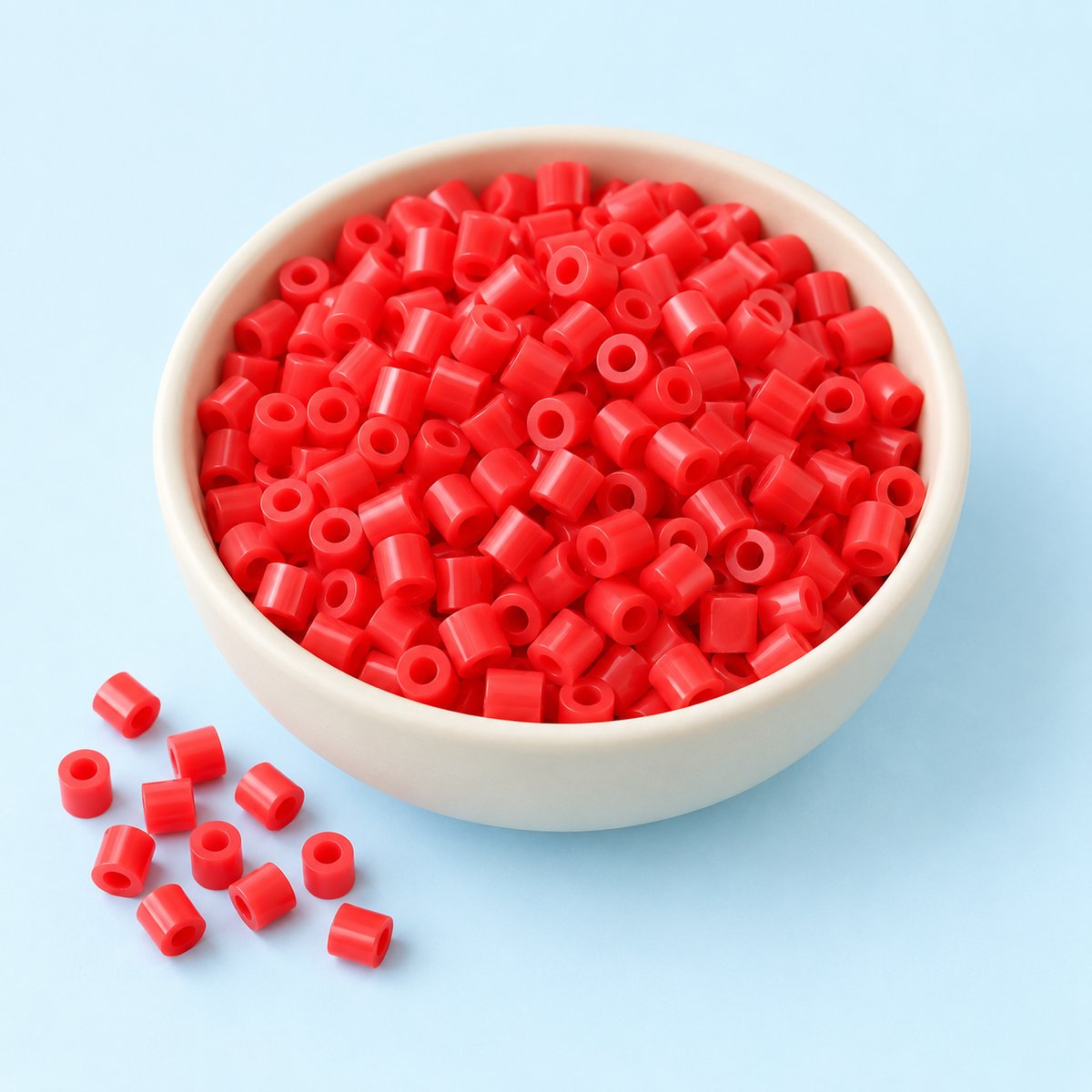Concept image of cherry red fuse beads on a soft blue background