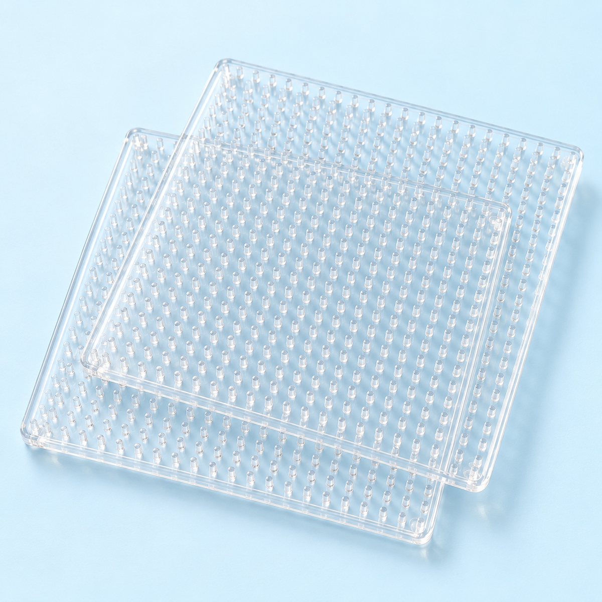 Concept image of two clear square fuse bead pegboards